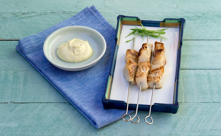 Barbecued Patagonian Toothfish Skewers with Wasabi Mayonnaise in a black dish.