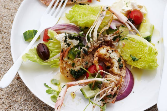Grilled Scampi With Greek Salad on a white plate.