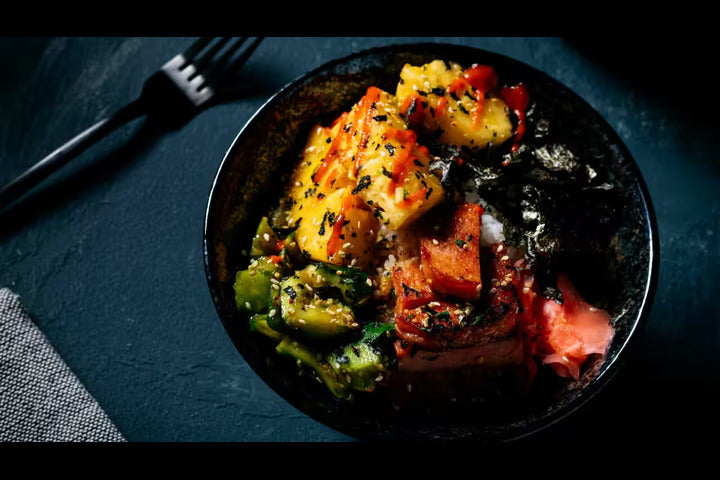 Abalone with Chilli & Garlic on a black plate.