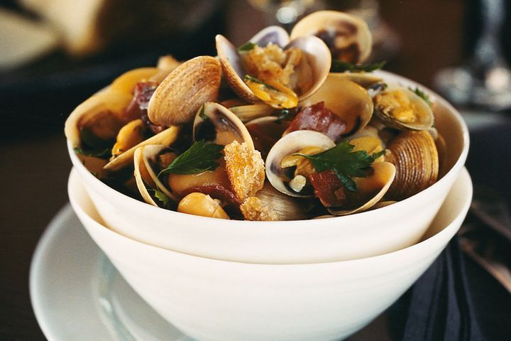 Clams With Manzanilla And Beans in white bowl.