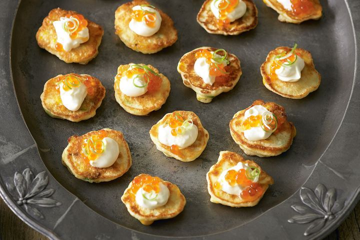Corn Fritters With Salmon Roe on black tray.