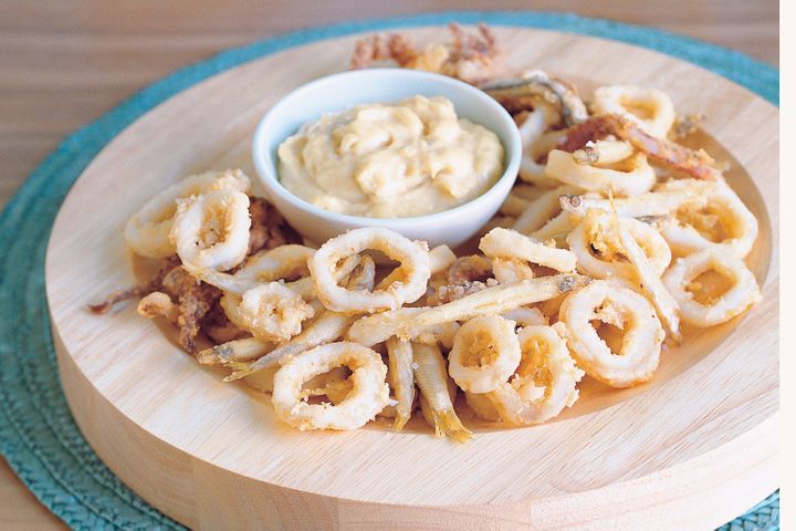 Crisp Whitebait And Calamari With Quince Aioli presented on a chopping board.