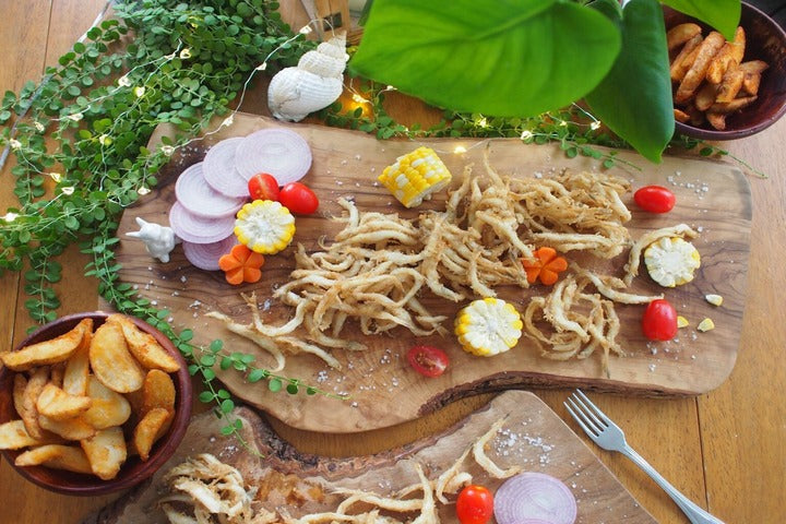 Crispy Silver Fish presented on chopping board.