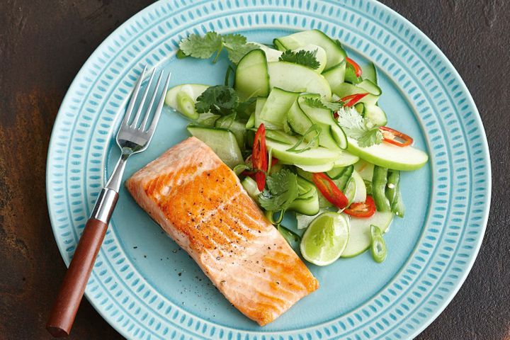 Grilled Ocean Trout With Apple, Lime And Cucumber Salad on a blue plate.