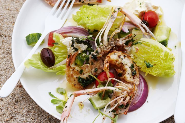 Grilled Scampi With Greek Salad on a white plate.
