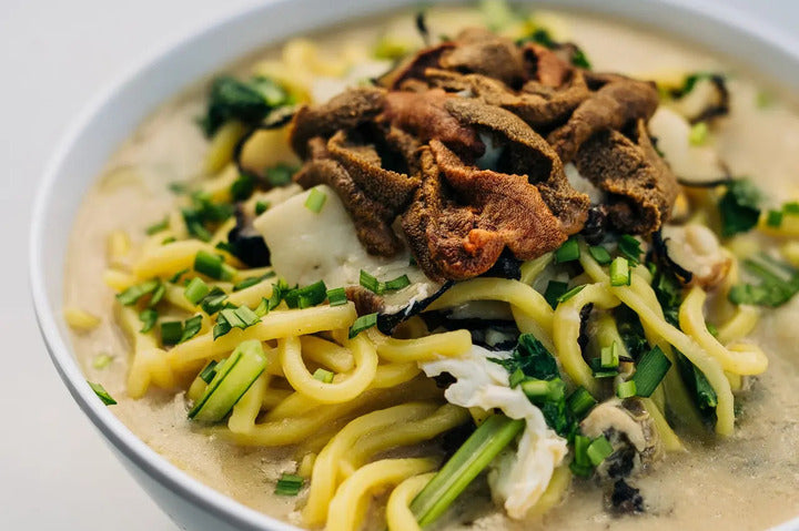 Luxe Lo Mein With Abalone And Sea Urchin Roe in a bowl.