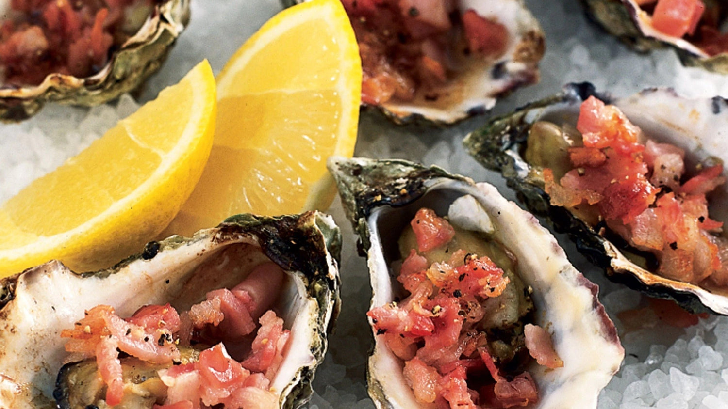Oysters Kilpatrick displayed on ice.