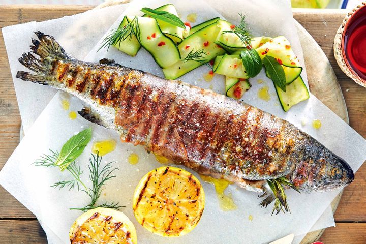 Prosciutto Wrapped Rainbow Trout With Cured Zucchini Salad on a serving plate.