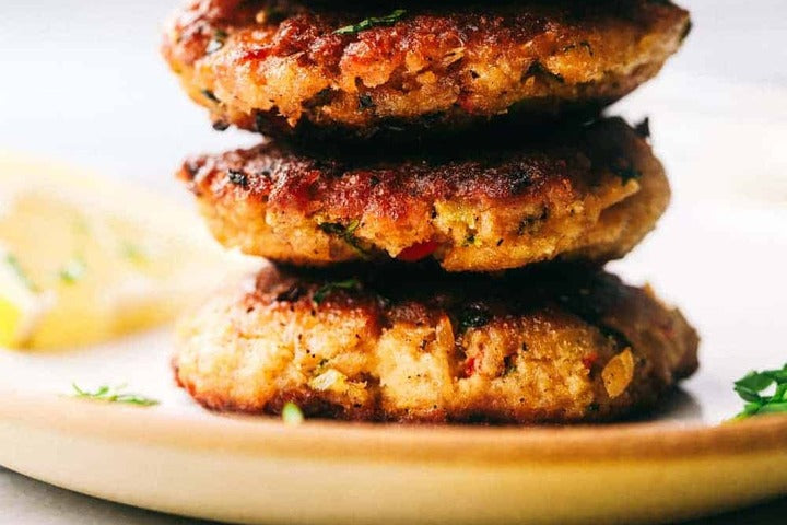 Salmon Croquettes stacked high on a plate.