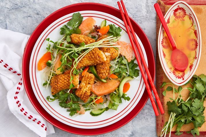 Salt And Pepper Squid And Noodle Salad presented on a red plate.