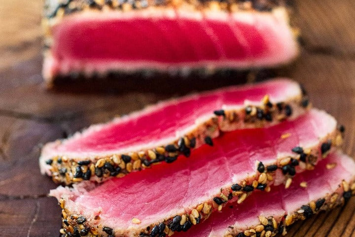 Seared Tuna Saku presented on chopping board.