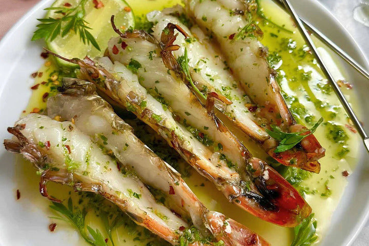 Skull Island Prawns With Dashi Butter, Shoyu Sesame, And Samphire displayed on white plate.