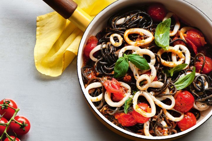 Squid Ink Pasta With Calamari displayed in black pot.