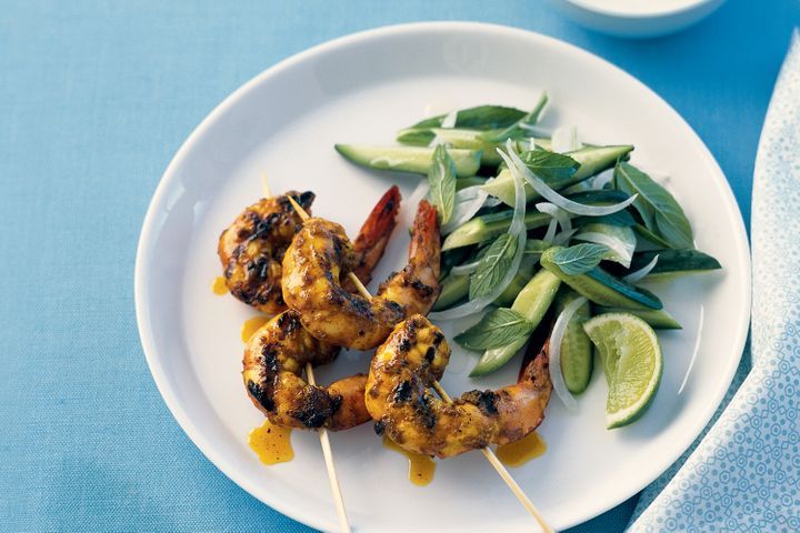 Turmeric Spiced Prawns With Yoghurt And Cucumber Salad on a plate.