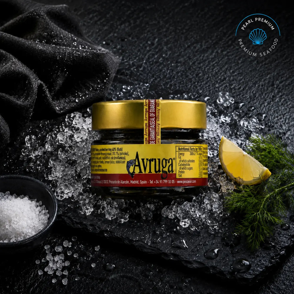 Jar of Avruga caviar displayed on black slate with crushed ice and lemon