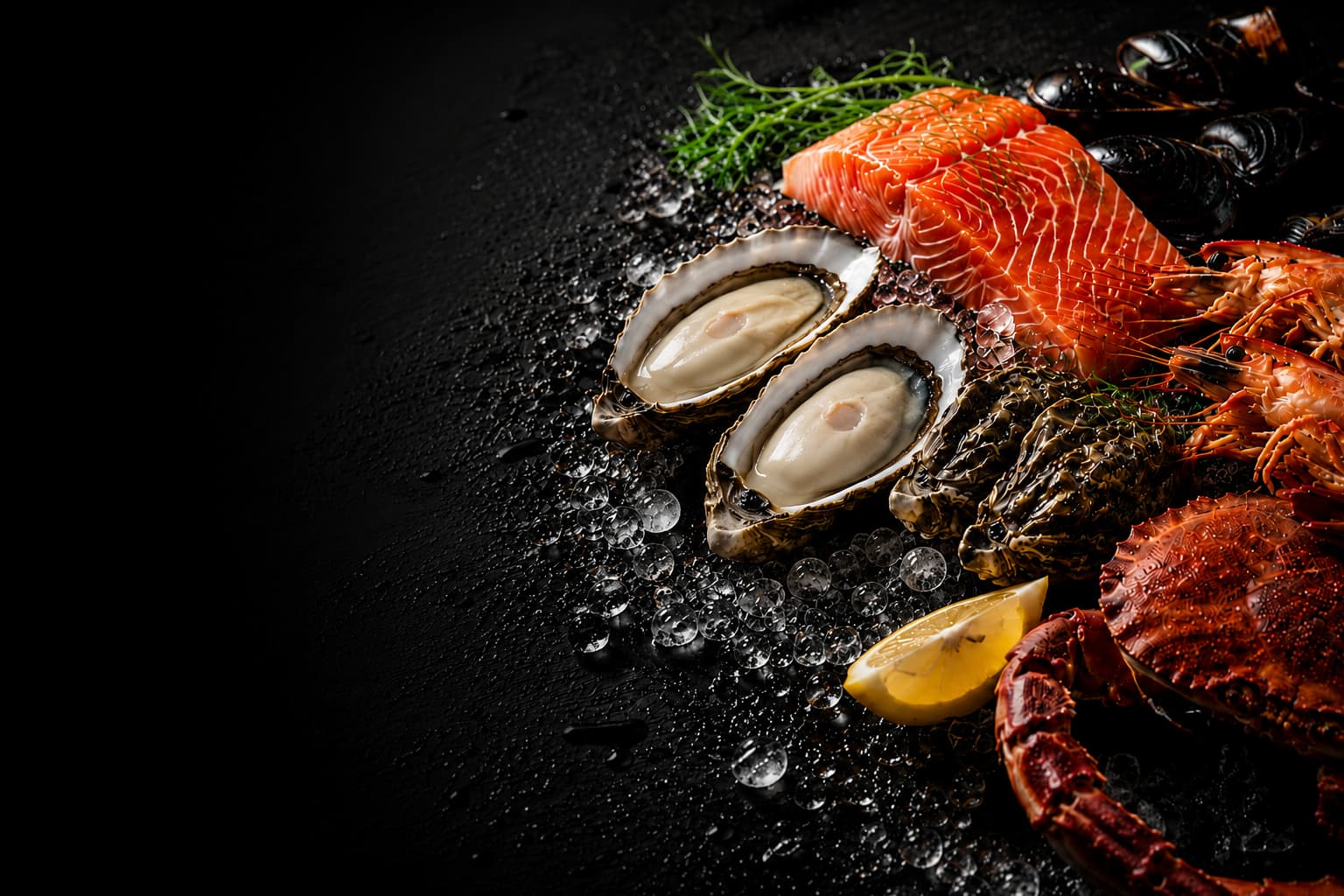 Assorted seafood including oysters, salmon, and crab on a dark surface with a lemon wedge.
