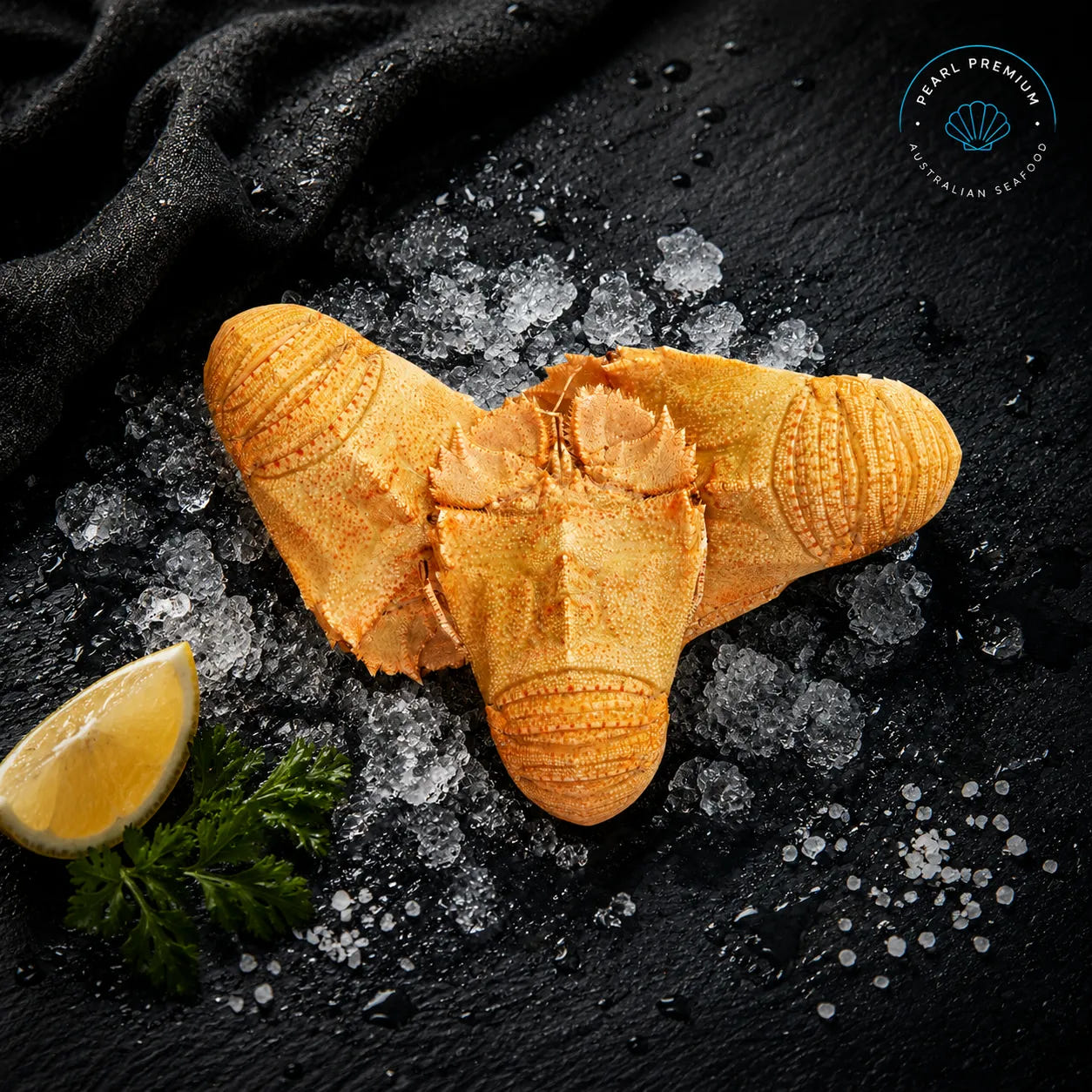 Fresh cooked moreton bay bugs displayed on black slate with crushed ice and lemon