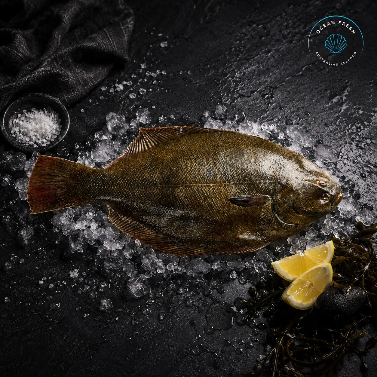 Fresh whole flounder displayed whole on crushed ice with lemon