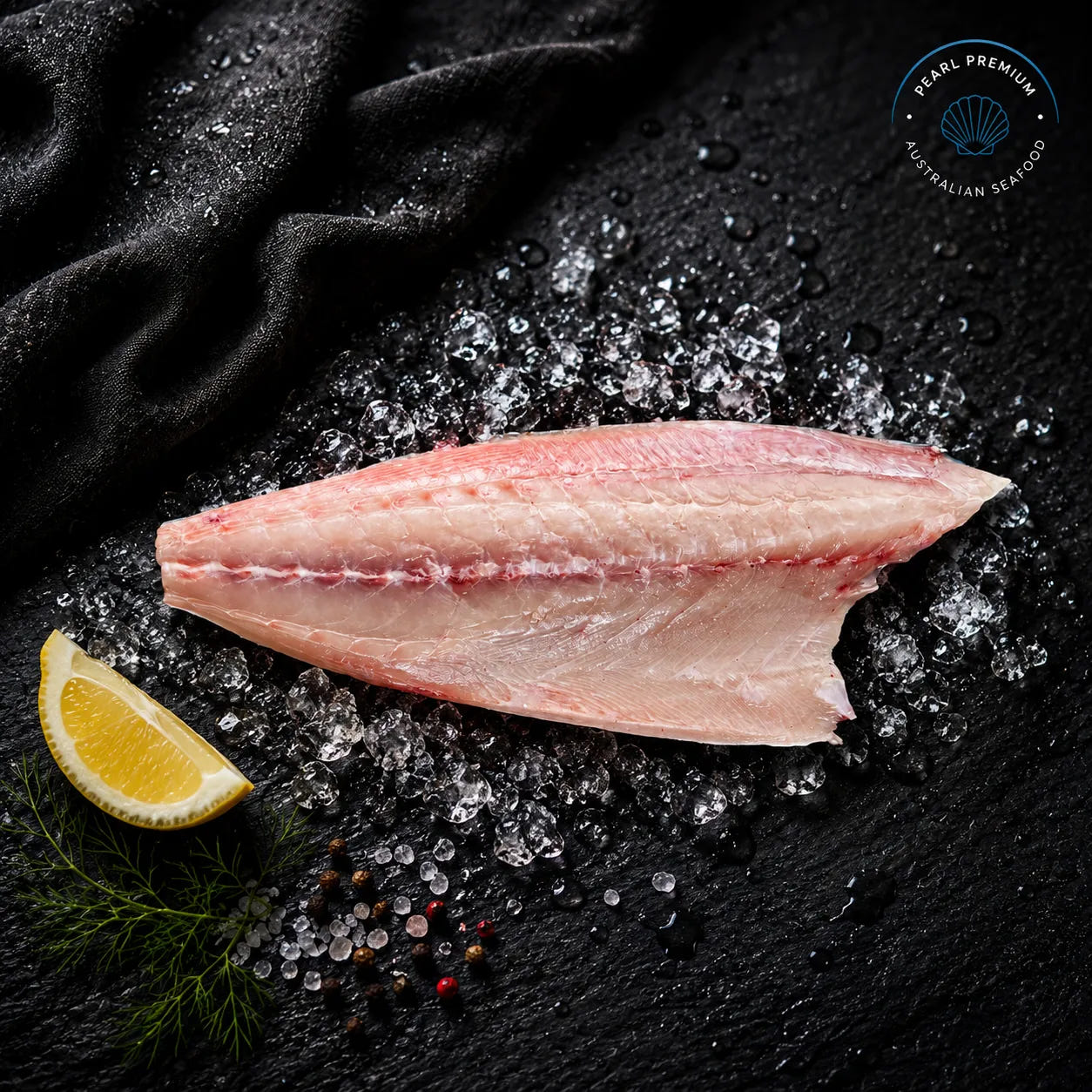 Fresh hiramasa kingfish fillet displayed on black slate over crushed ice with lemon