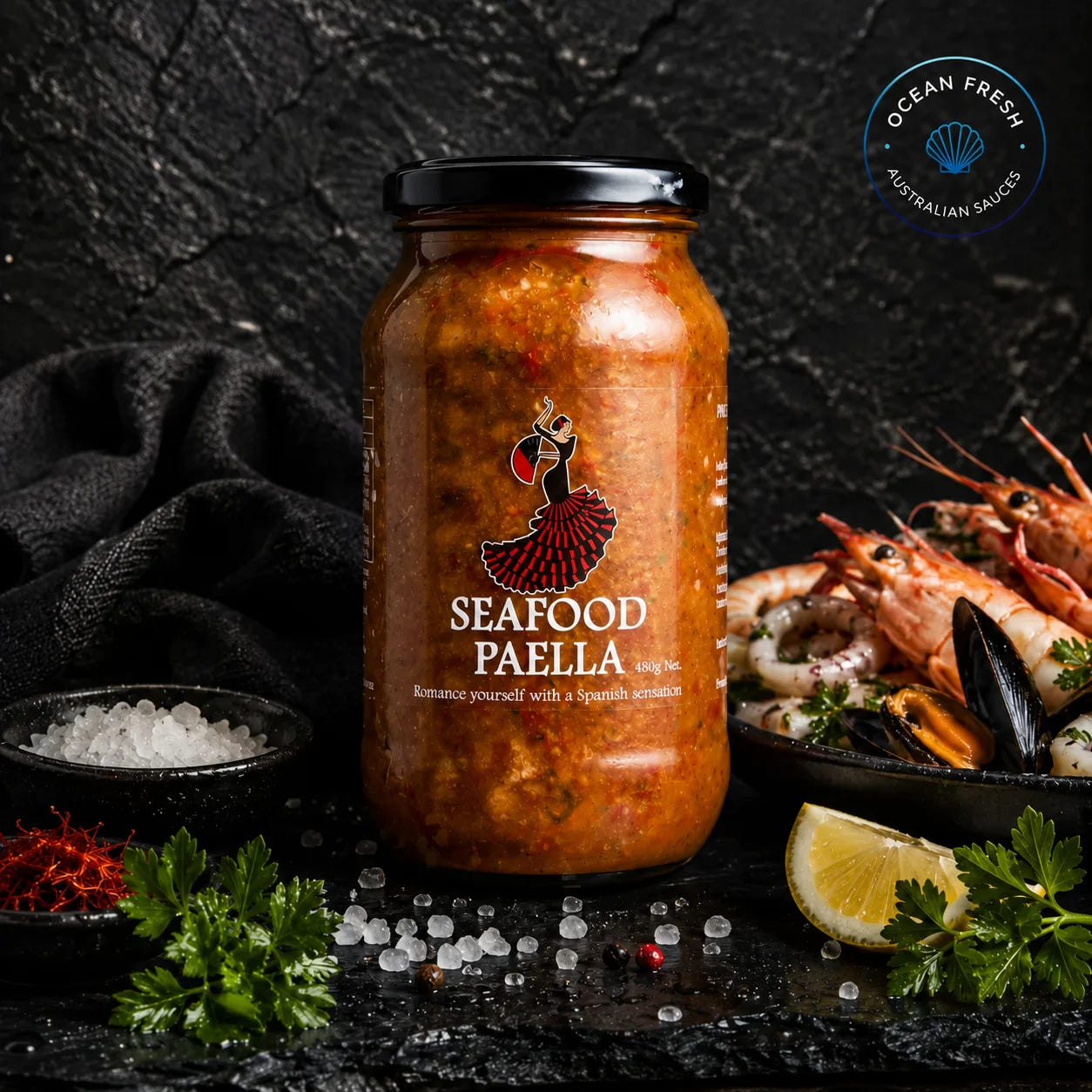 Jar of Seafood Paella Sauce presented on dark stone beside prepared seafood and lemon