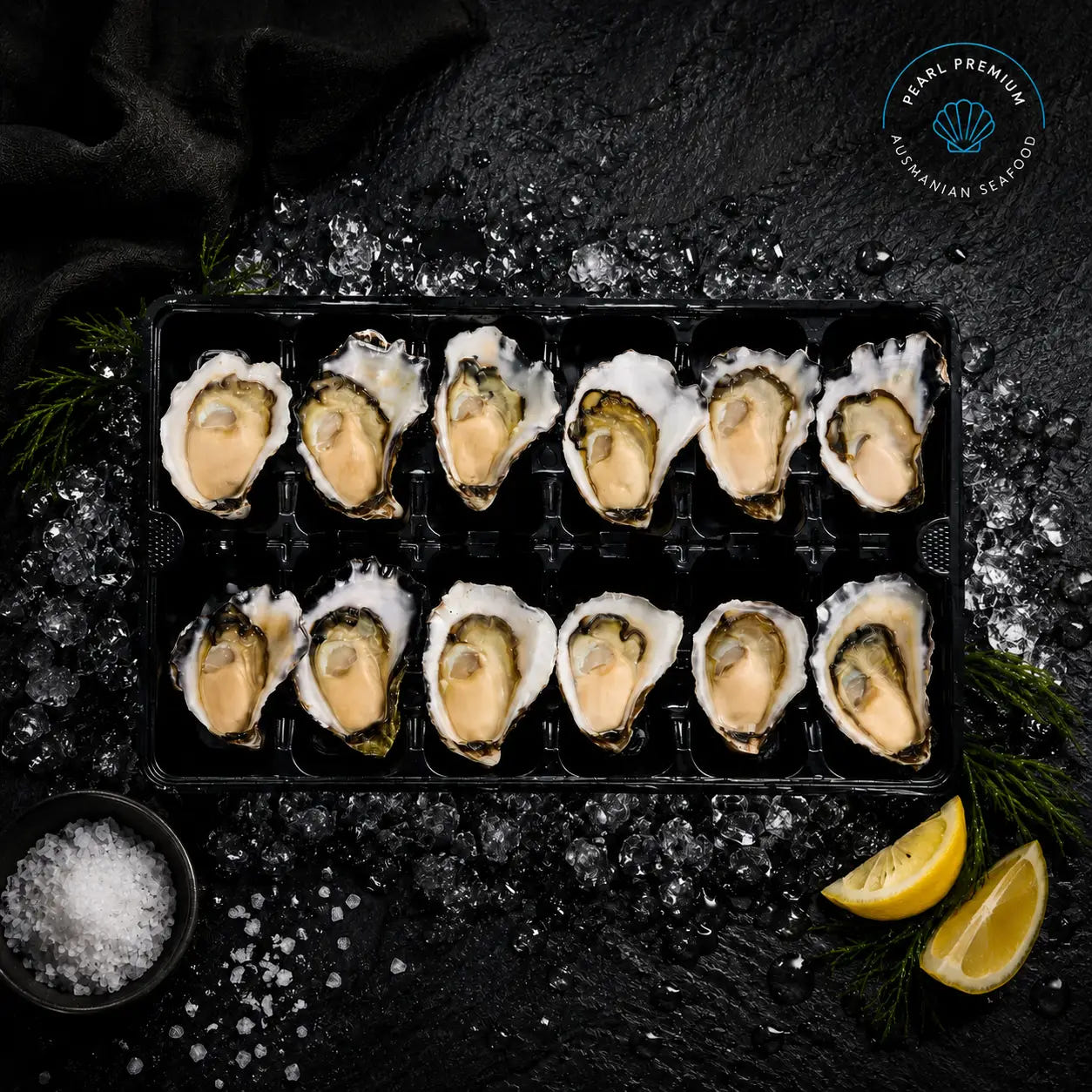A dozen Sydney rock oysters on the half shell in a tray, set on ice with lemon