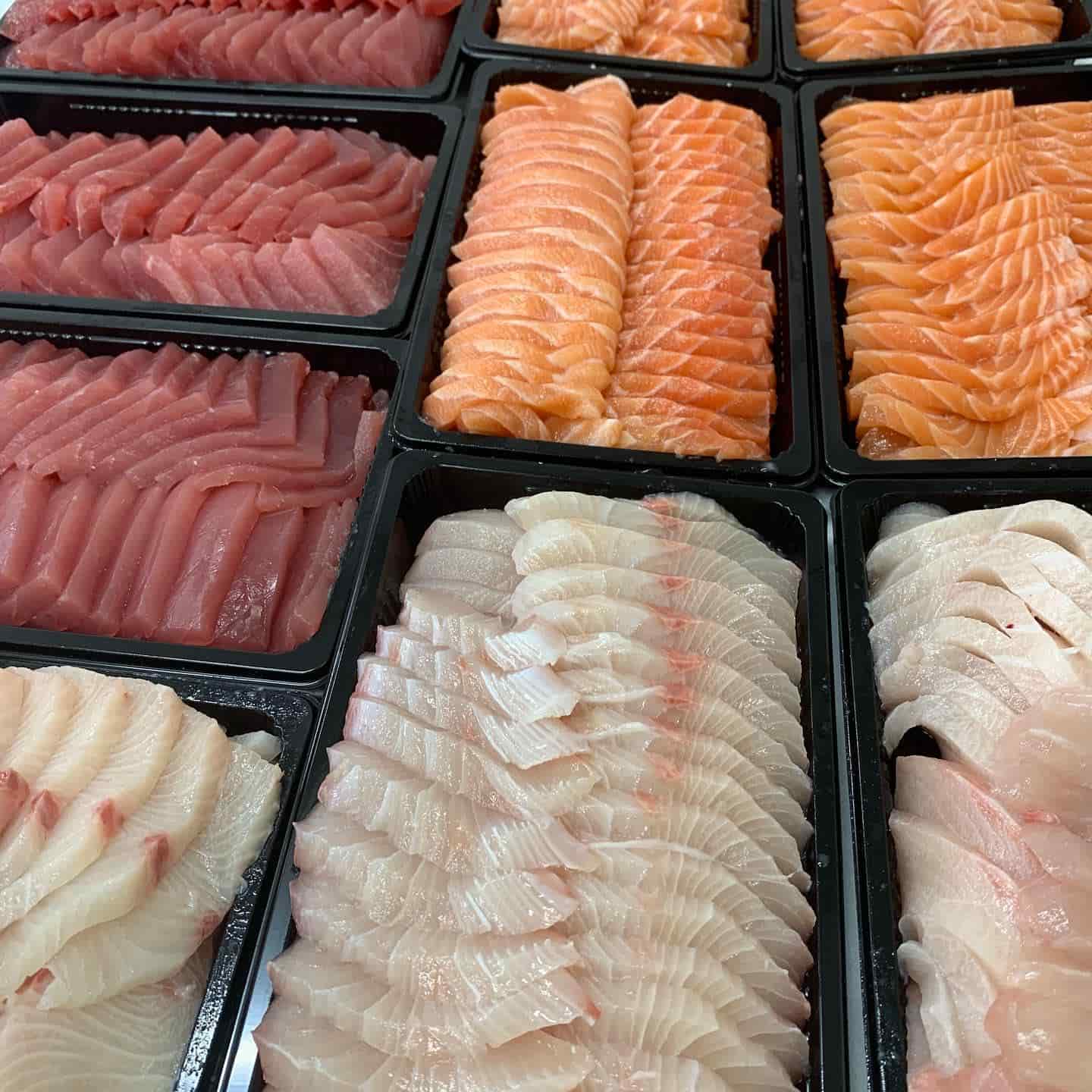 Premium sashimi platters featuring a variety of fresh, premium tuna, salmon & kingfish, beautifully arranged in black trays.
